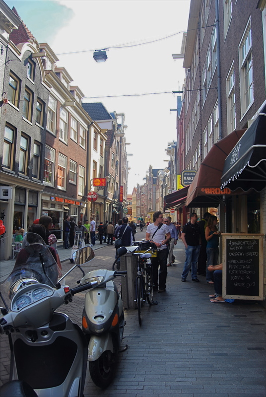 4 - A lively street scene dotted with shops, restaurants, and a significant number of bicycles in Amsterdam